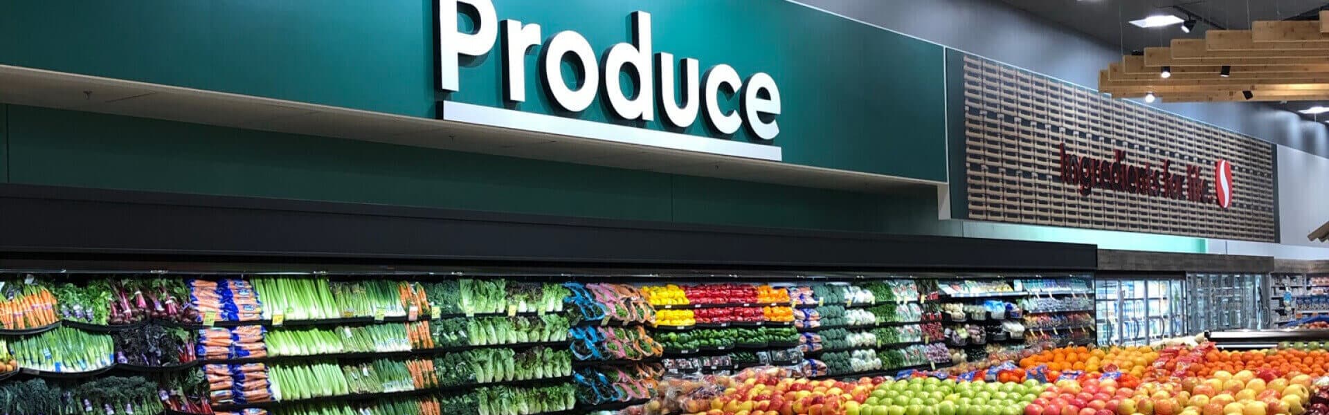 An image of a grocery store filled with lots of fresh vegetabels and fruits.